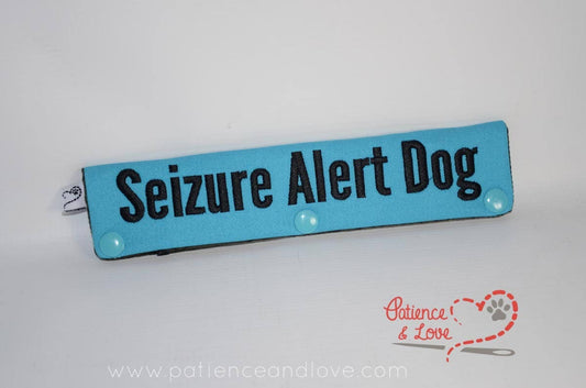 Picture is of a teal sleeve with black text.  It says seizure alert dog on it.